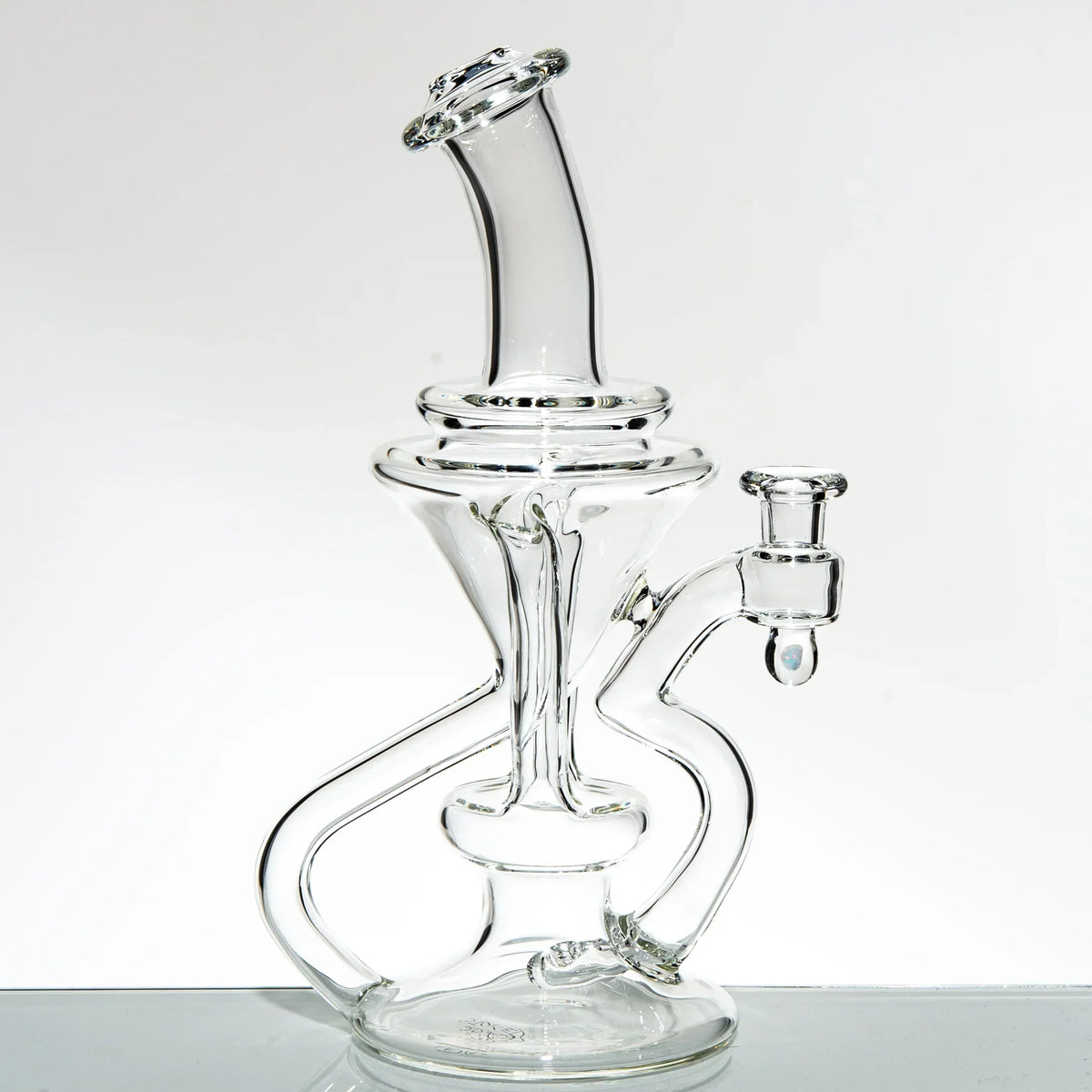 Clear glass recycler water pipe with intricate curved tubing on a white background