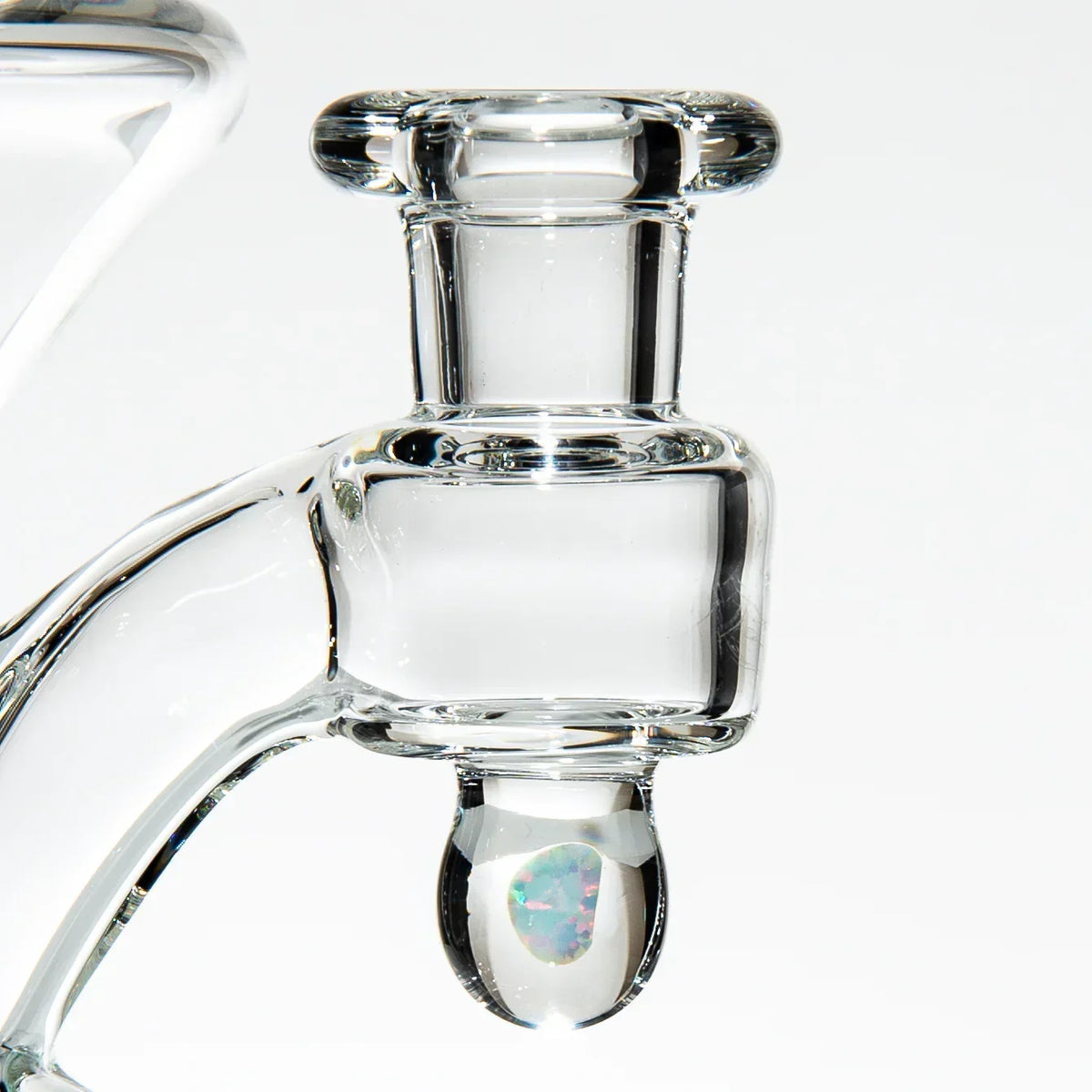 Close-up of a clear glass recycler joint with opal marble accent on a white background