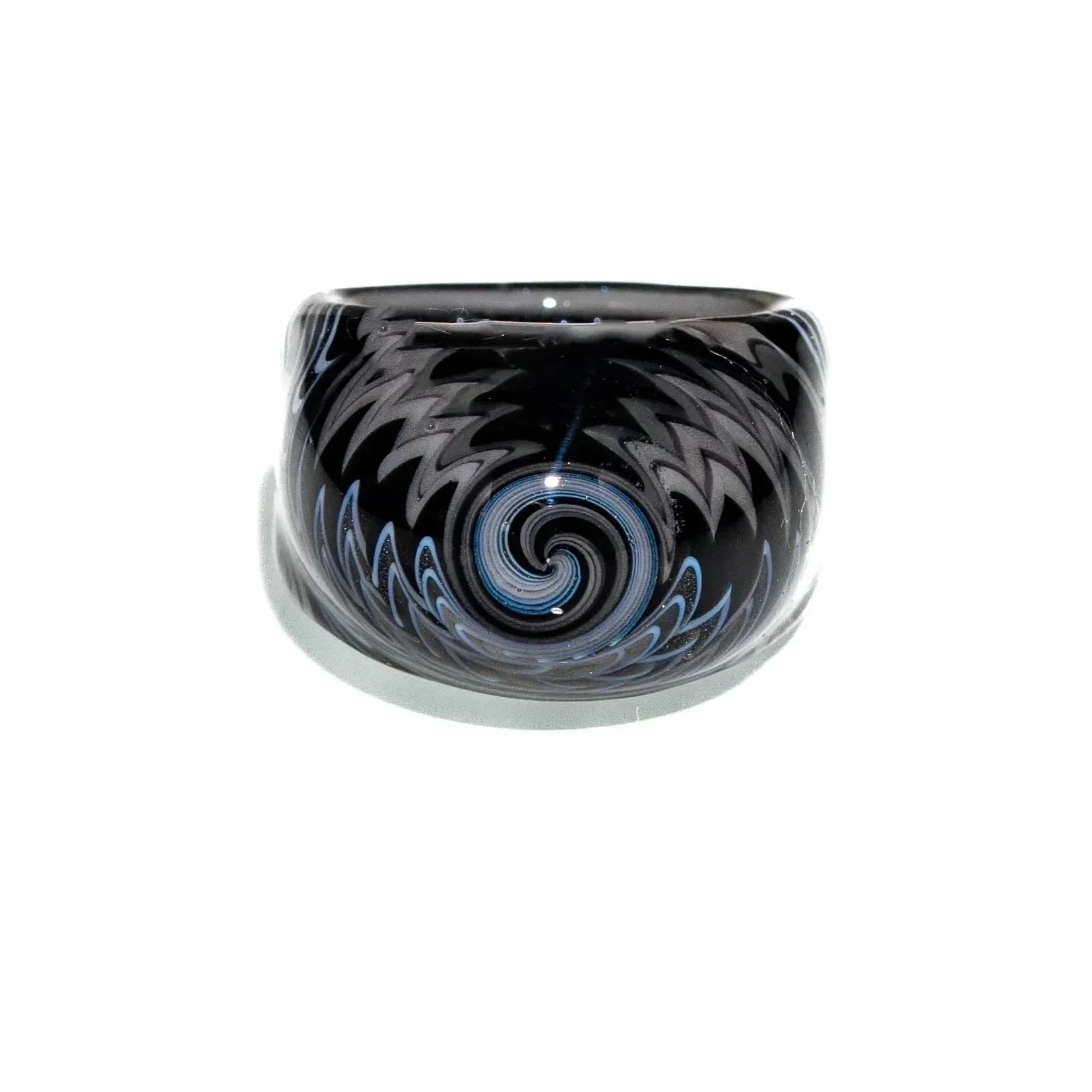 Black and white glass ring with intricate wig wag swirl pattern on a white background