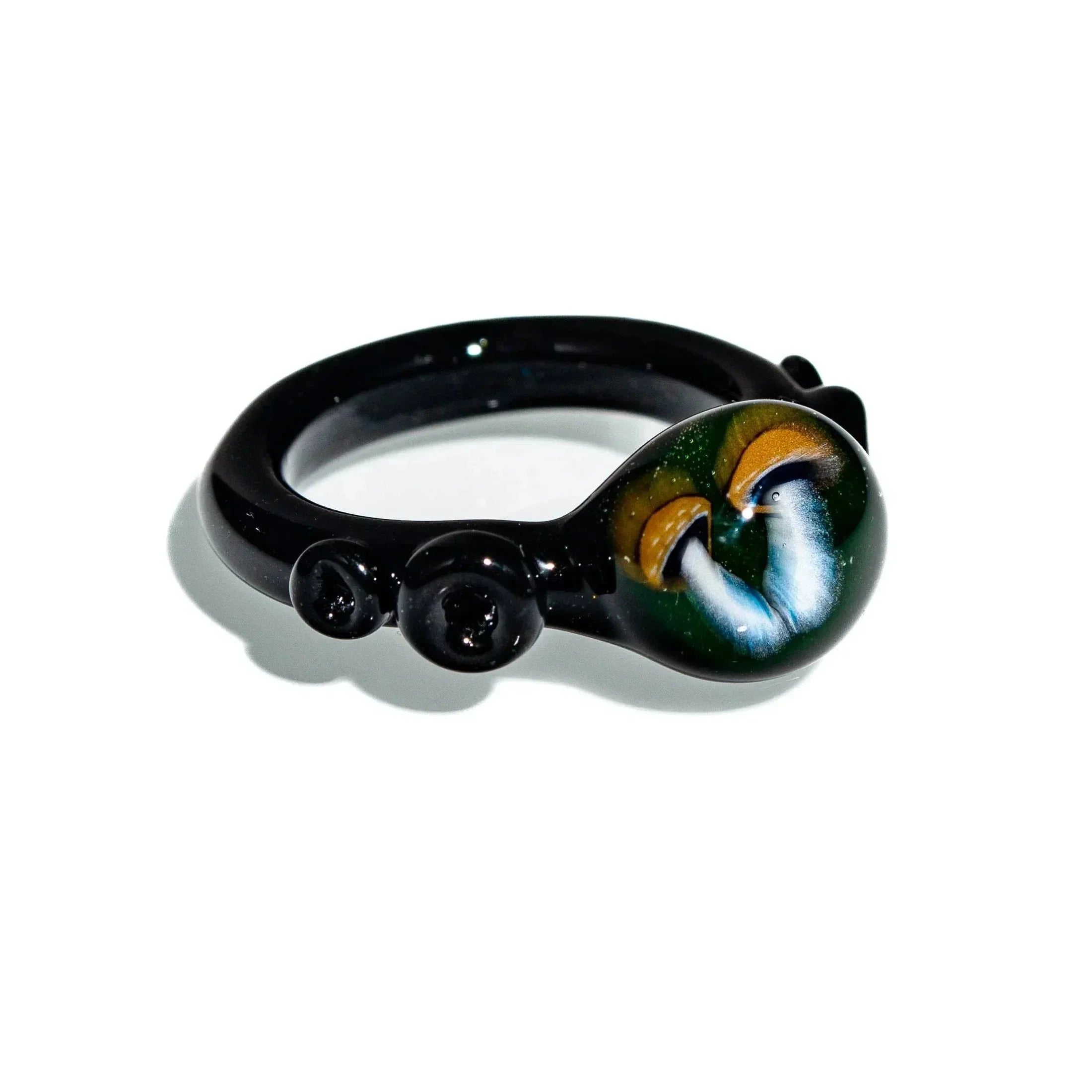 Black glass ring with hand-painted mushroom design on round top, displayed on white background