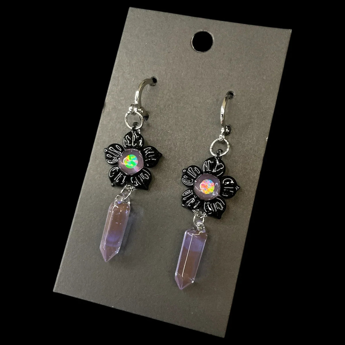Handmade crystal earrings with iridescent stones and black flower accents on display card