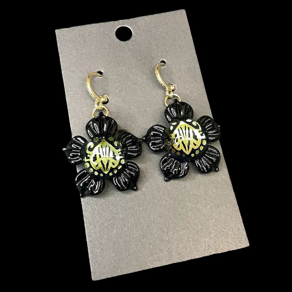 Handcrafted black glass flower earrings with gold accents on a display card