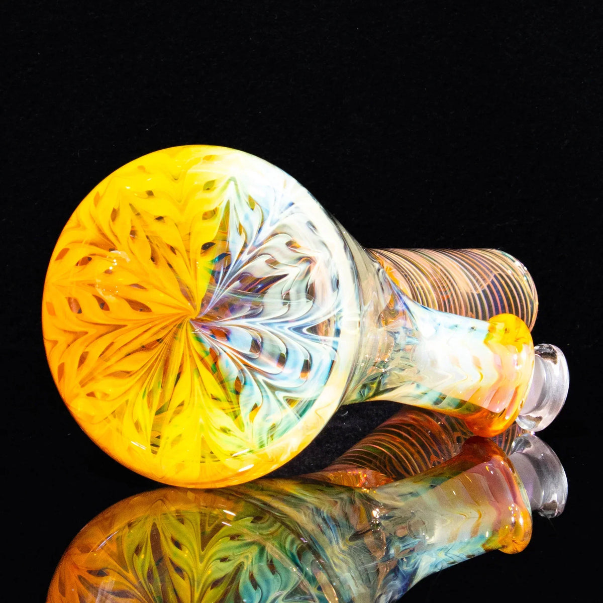Hand-blown glass mini tube with vibrant yellow and swirling multicolor pattern on black background