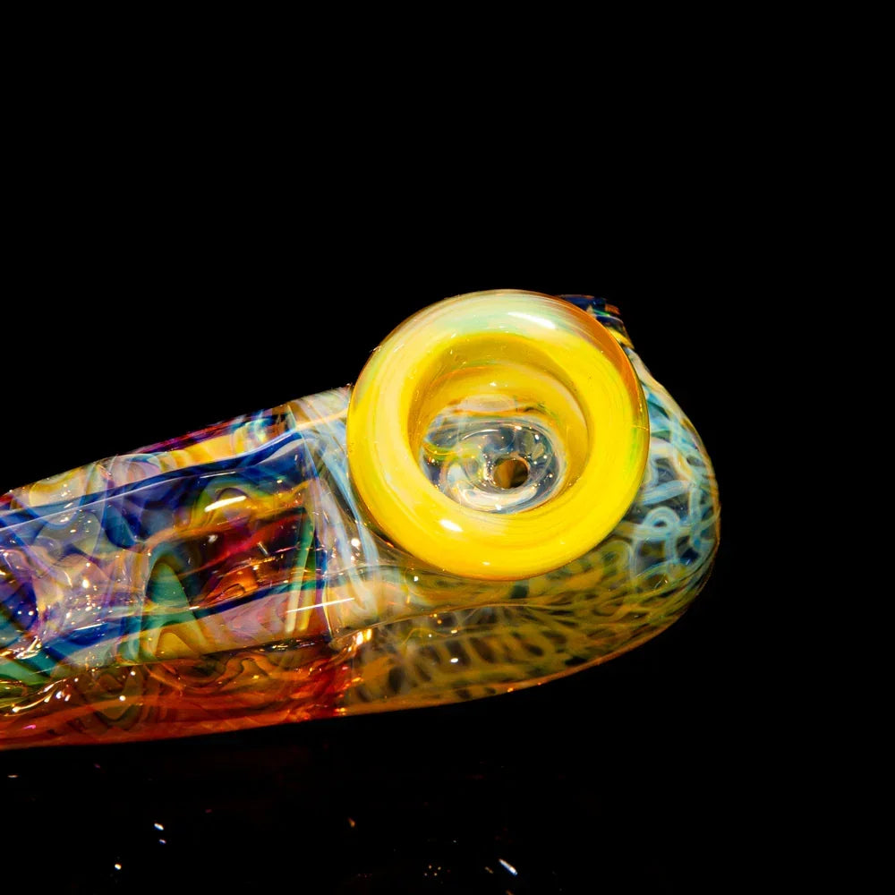 Colorful handcrafted glass pipe with yellow mouthpiece on a black background