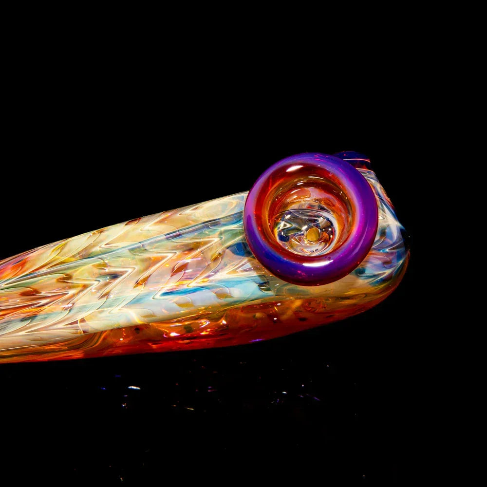 Colorful heady glass hand pipe with intricate swirls and vibrant accents on black background.