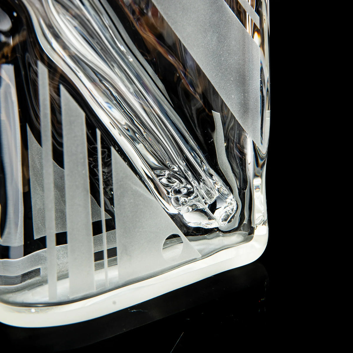 Close-up of thick clear glass pipe with geometric etched patterns and glossy finish