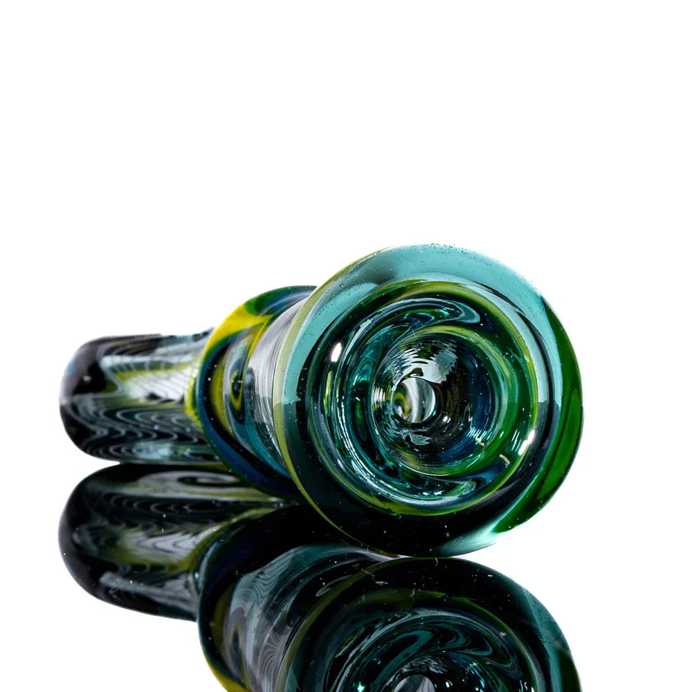 Colorful hand-blown glass pipe with yellow, green, and blue swirls on reflective surface