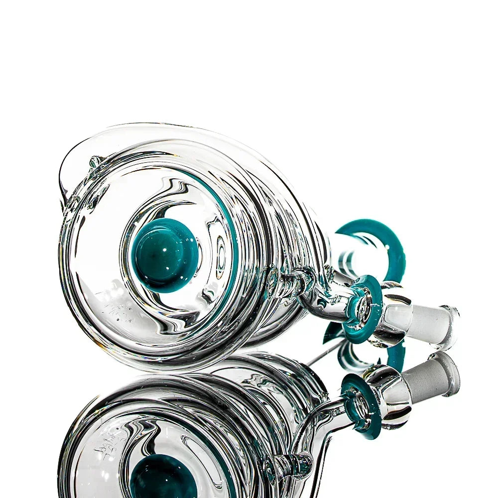 Clear glass water pipe attachment with teal accents reflected on a white background