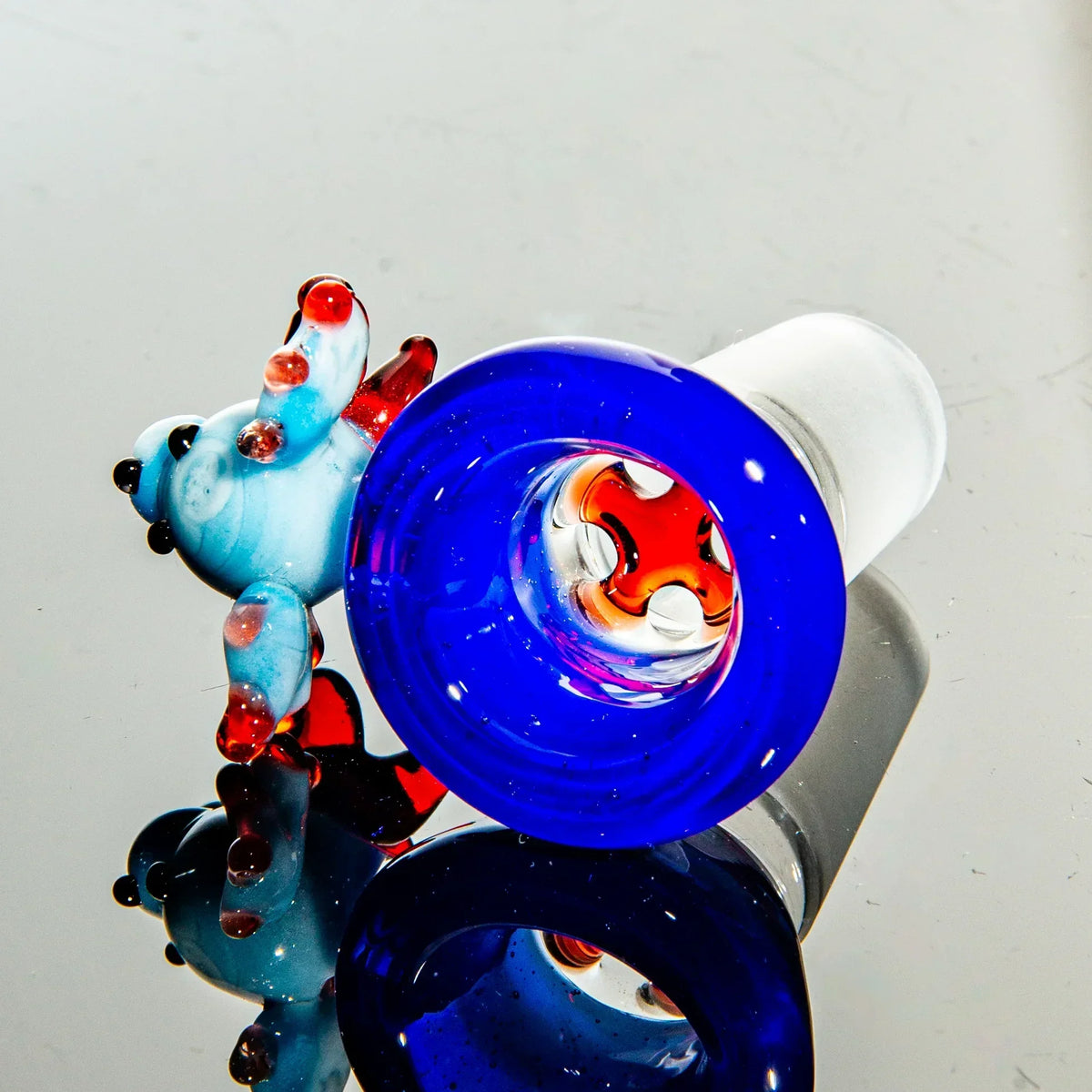 Colorful glass bowl piece with blue rim and a decorative bear for water pipes