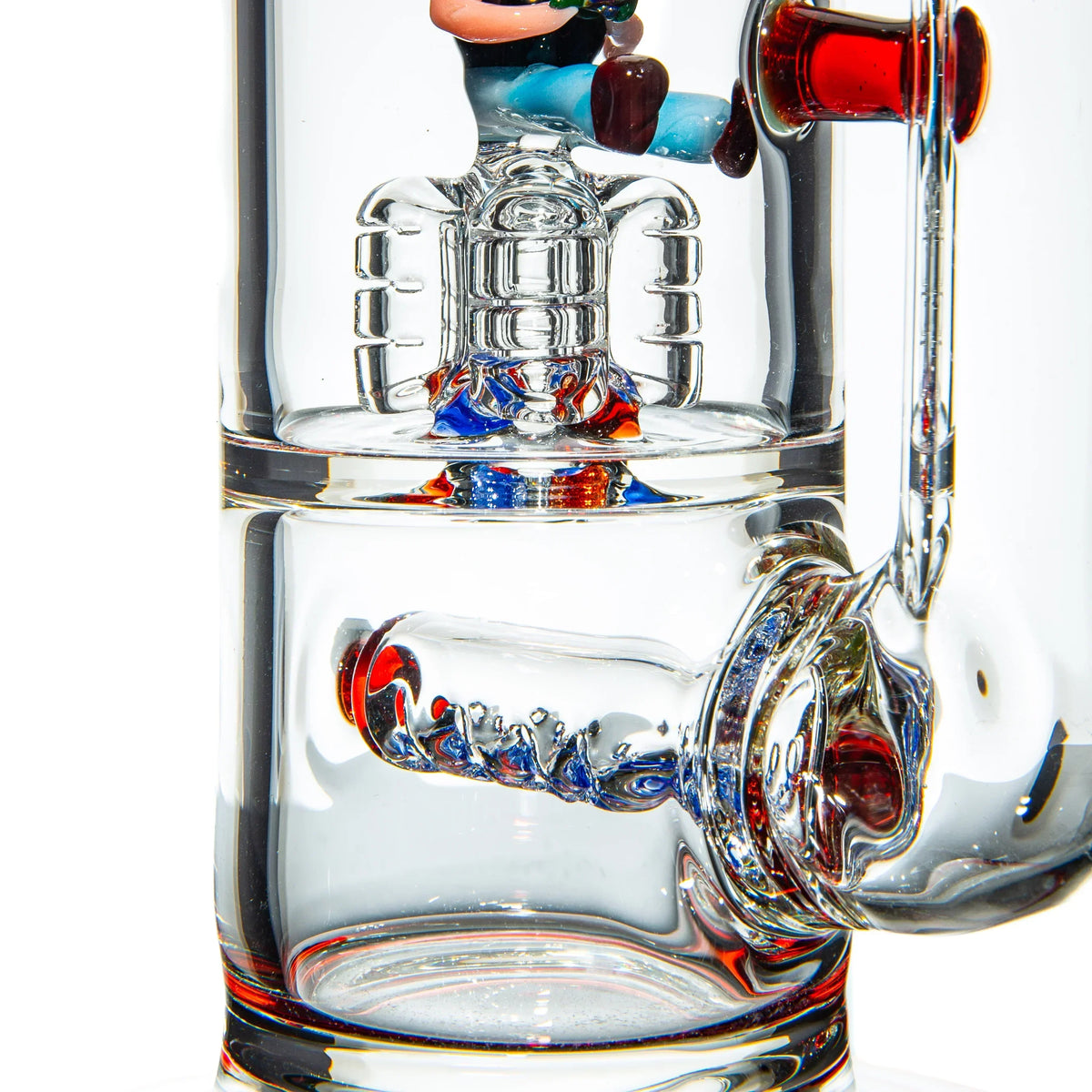 Close-up of a handcrafted glass water pipe with colorful percolator and character detail.