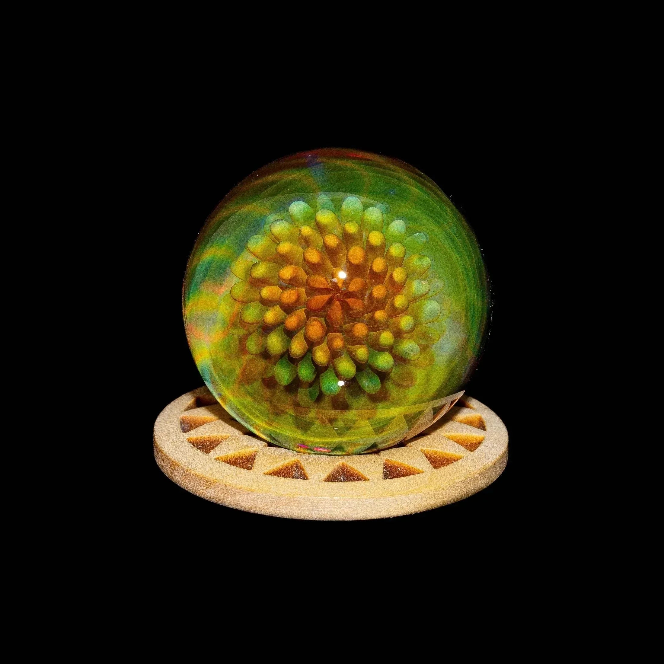 Heady glass marble with gold implosion and pinwheel design on wooden stand