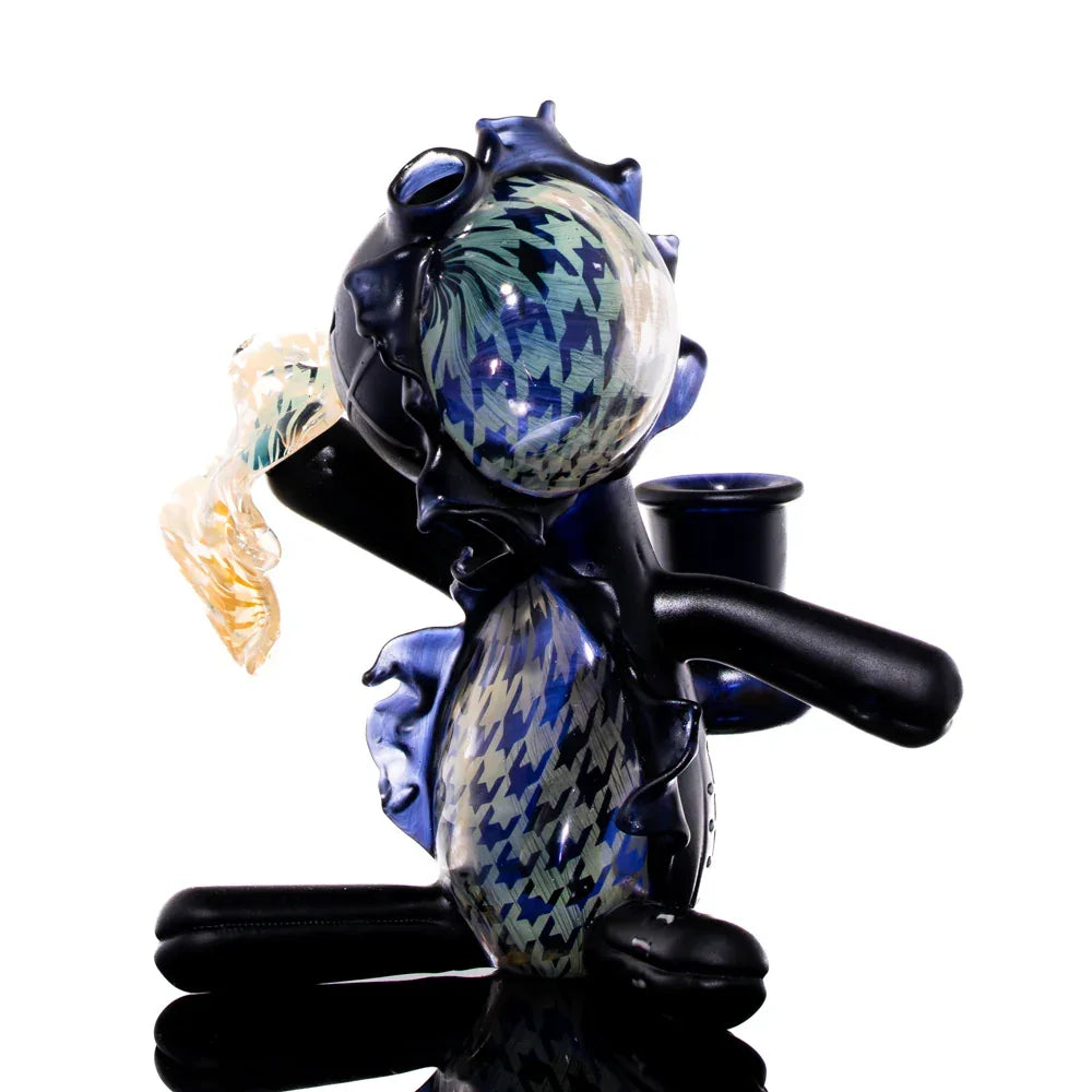 Handcrafted glass art pipe shaped like a doll with blue and houndstooth patterns.