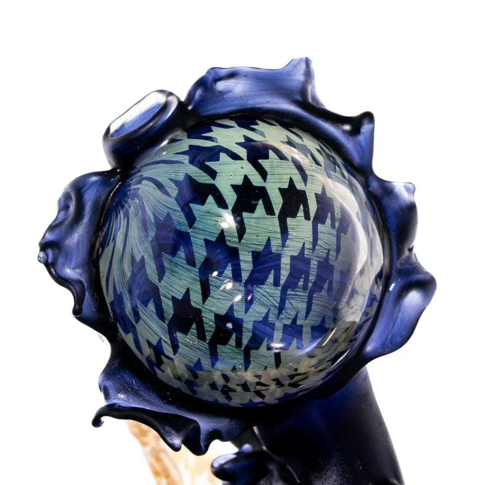 Close-up of artistic glass pipe with blue houndstooth pattern and abstract detailing