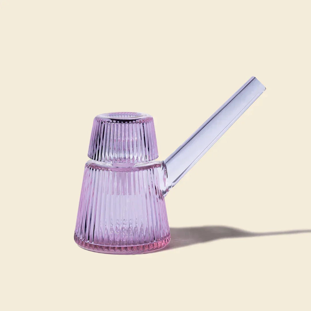 Purple ribbed glass bubbler pipe with angled mouthpiece on a light background