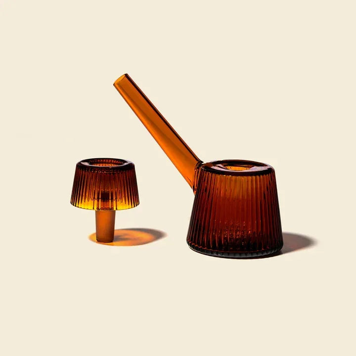 Amber glass bubbler with a modern ribbed design, photographed on a light background