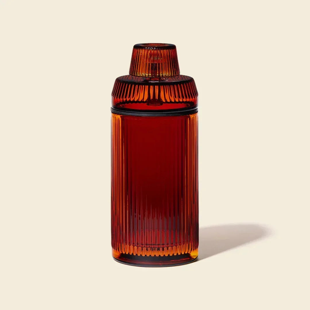 Amber glass gravity bong with ribbed texture on a plain background