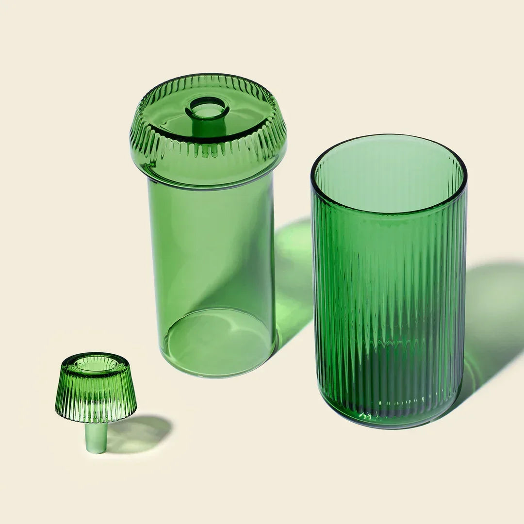 Modern emerald green glass gravity bong with ribbed texture, three separate parts, on neutral background