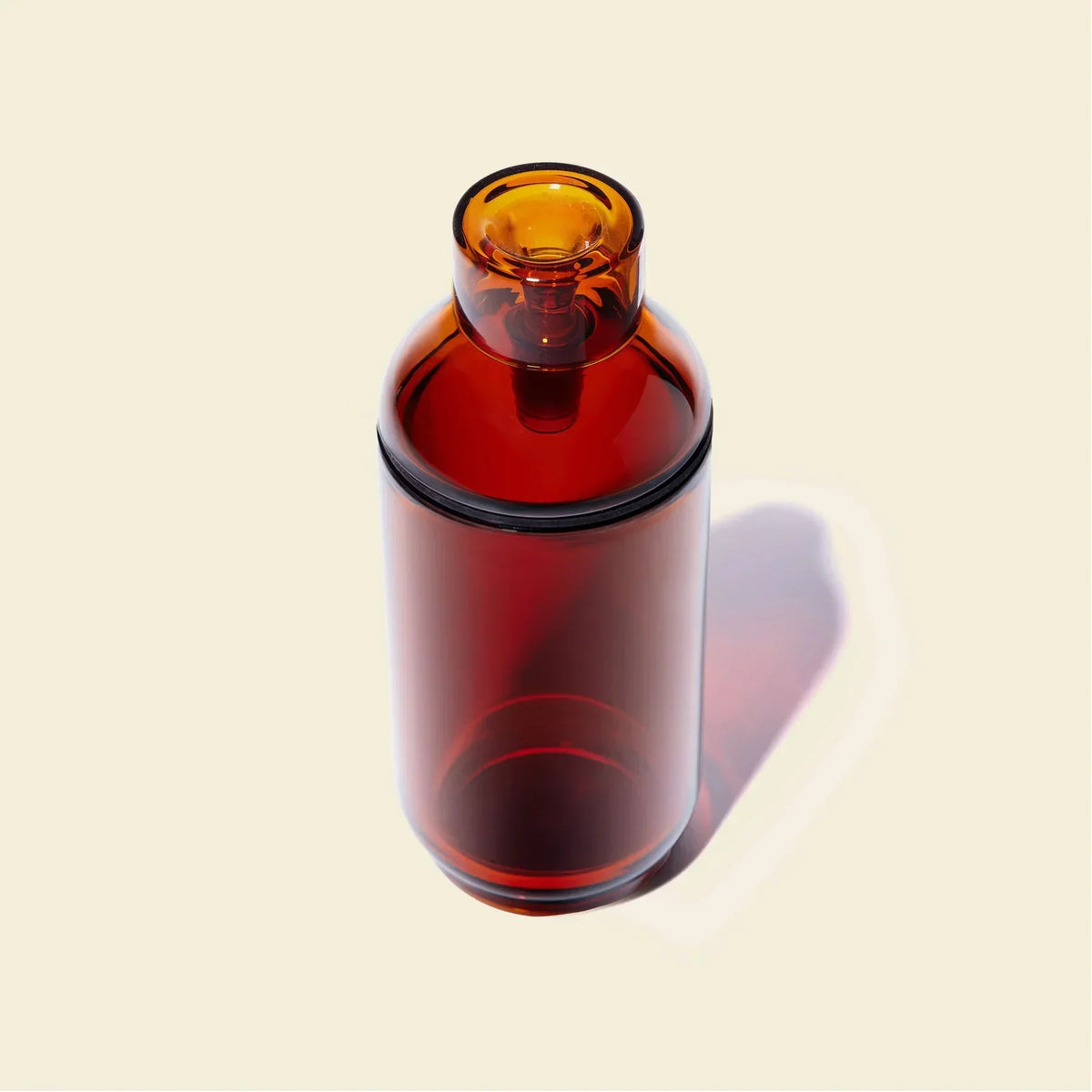 Amber glass gravity bong with minimalist design on beige background