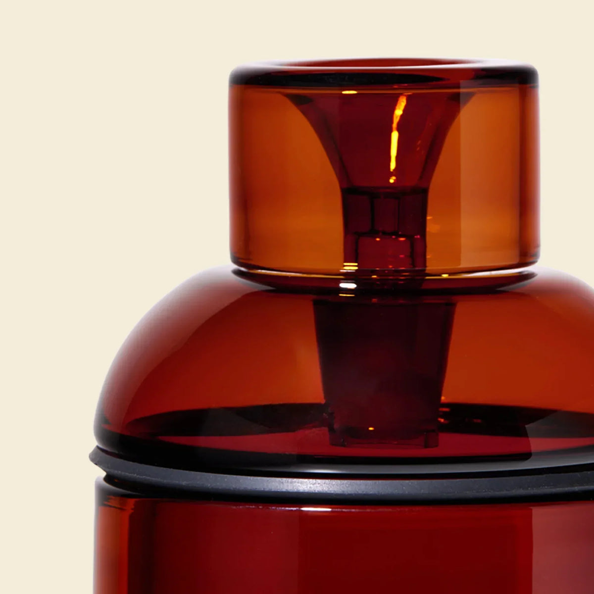 Close-up of amber glass gravity bong with modern design on neutral background