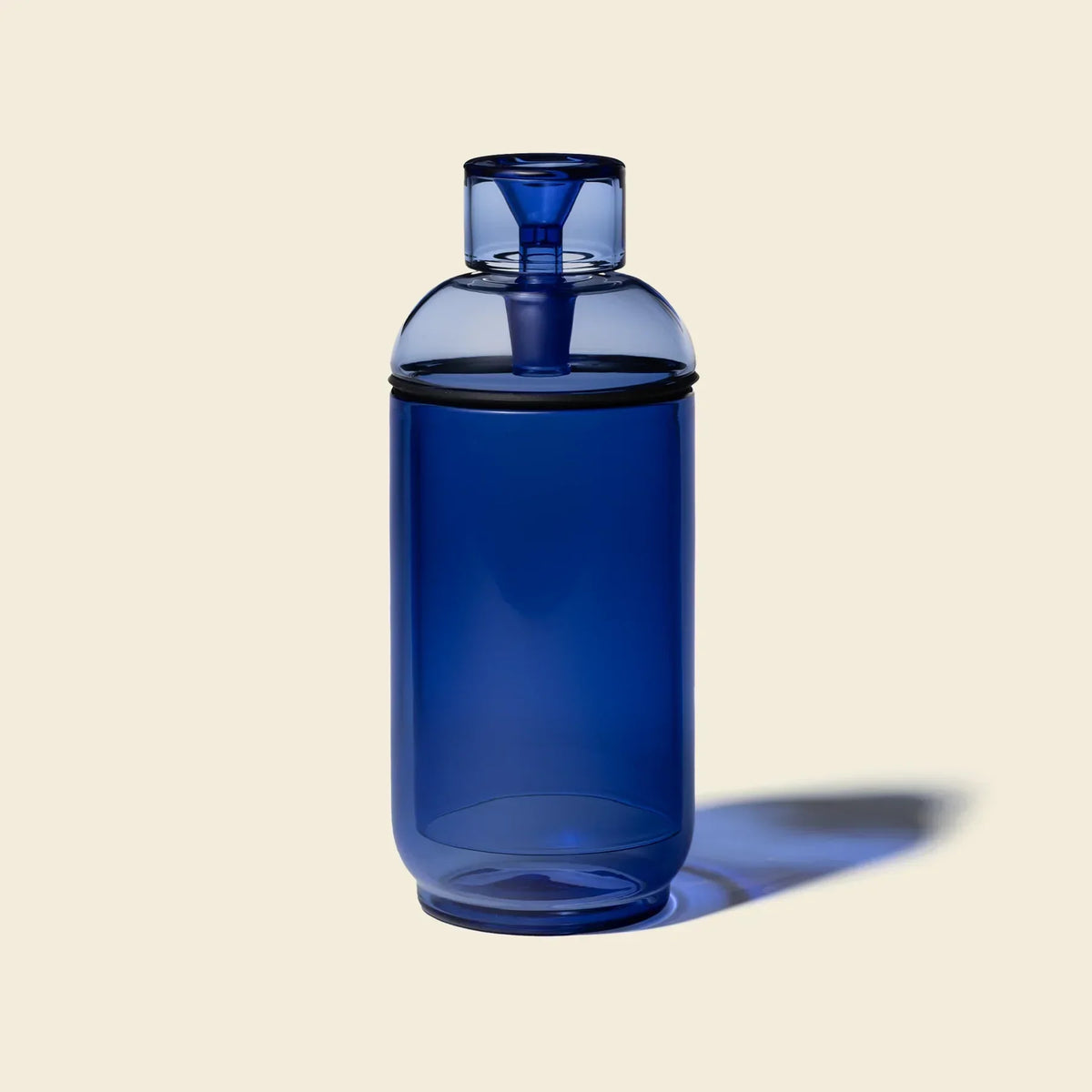 Blue glass gravity bong with modern design on a beige background