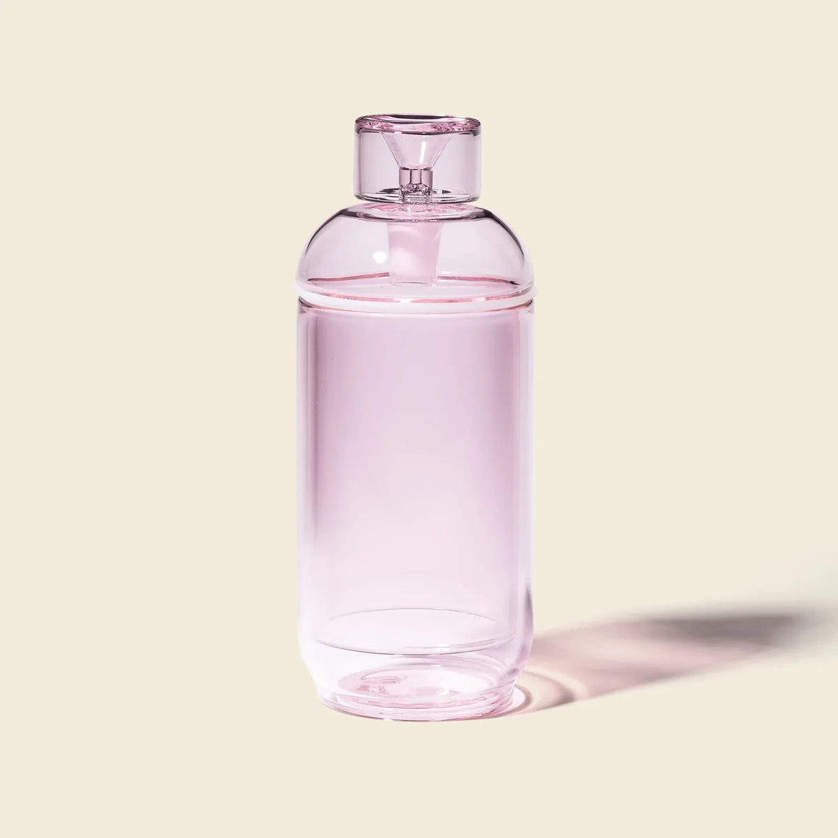 Pink glass gravity bong with modern minimalist design on neutral background