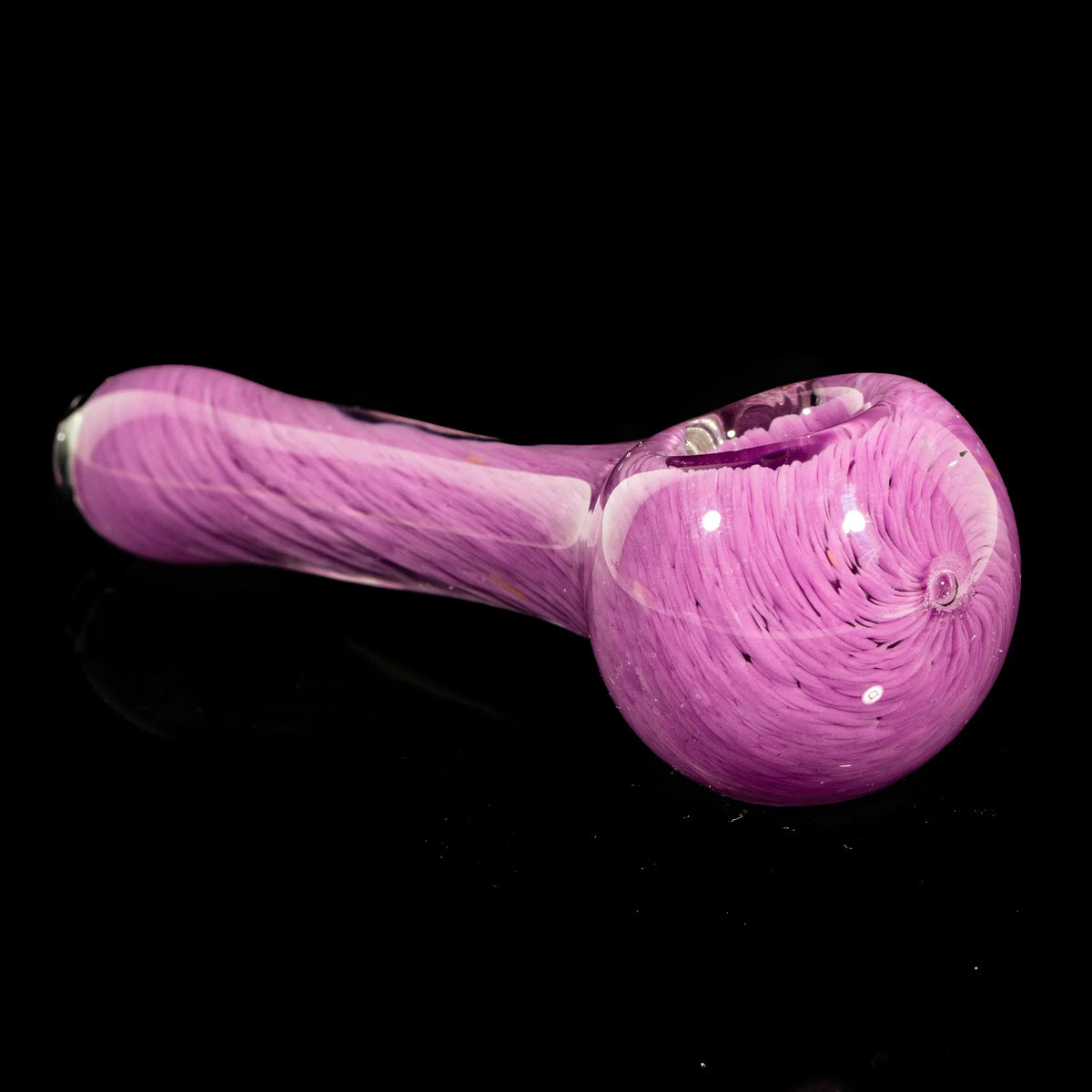 Purple glass hand pipe with swirling color frit design on a black background