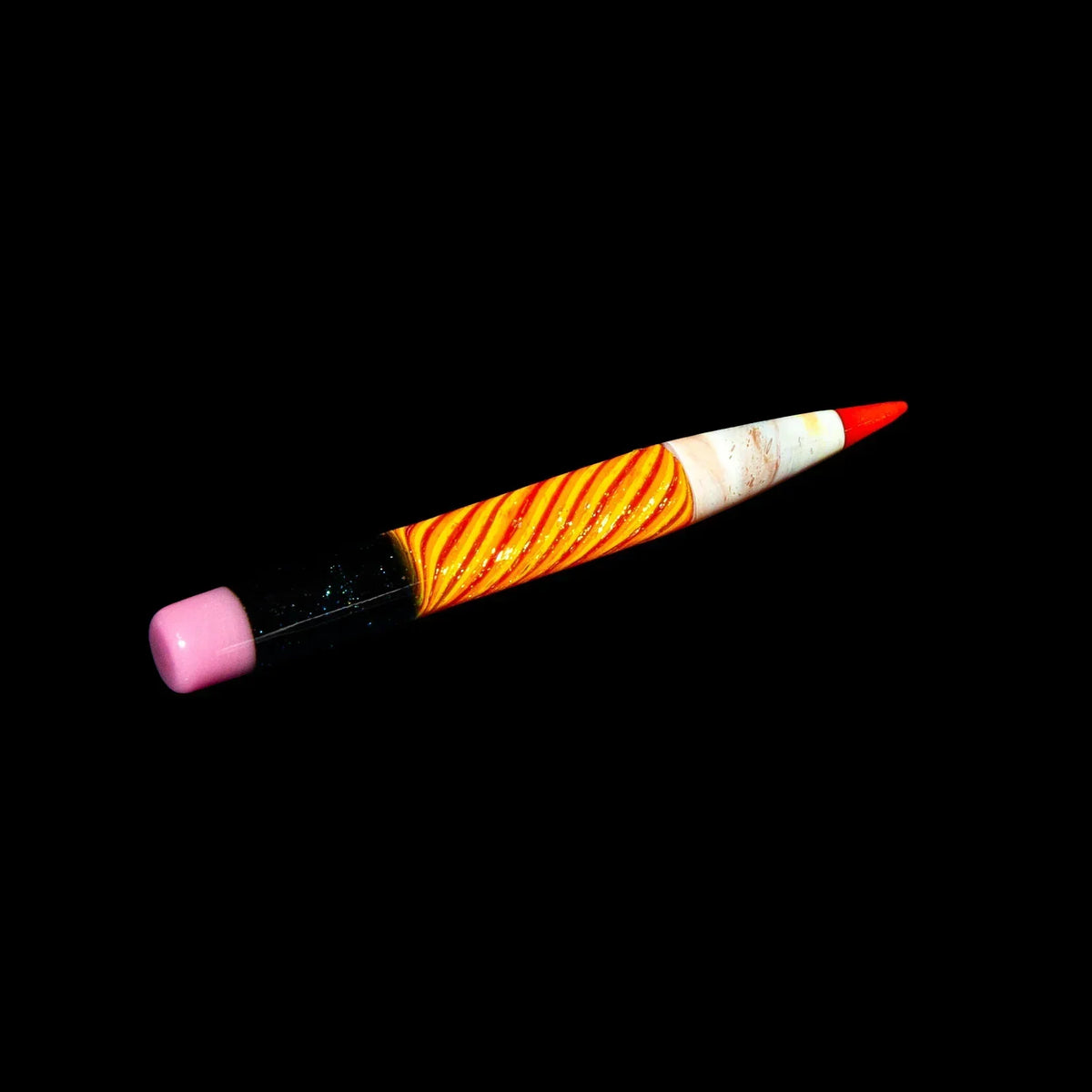 Dichroic glass pencil pipe with orange swirl design and pink eraser tip on black background