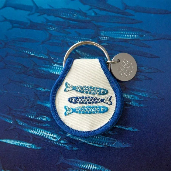 Embroidered patch keychain with blue fish design on ocean fish background
