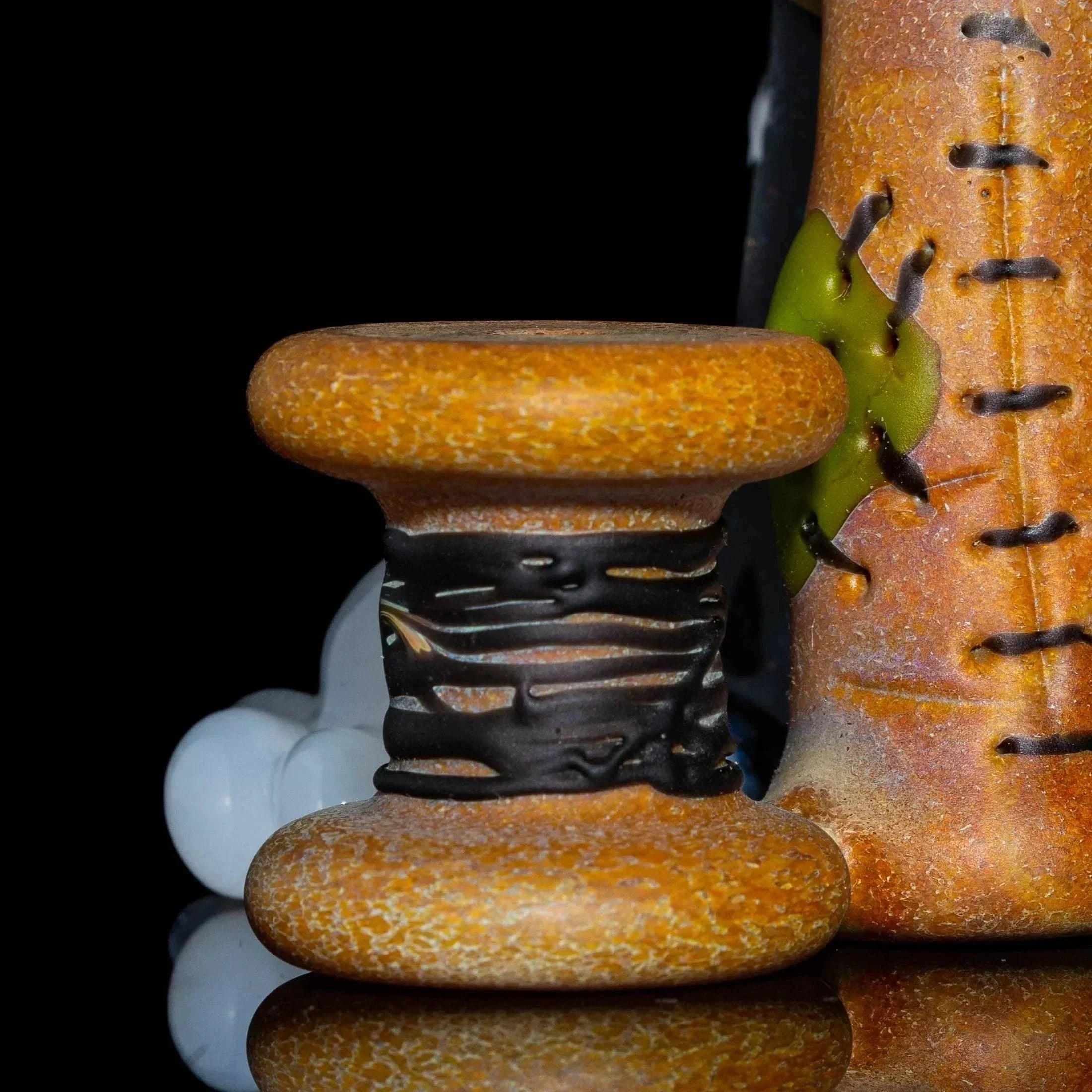 Detailed glass spool accessory with textured brown finish and black wrap design