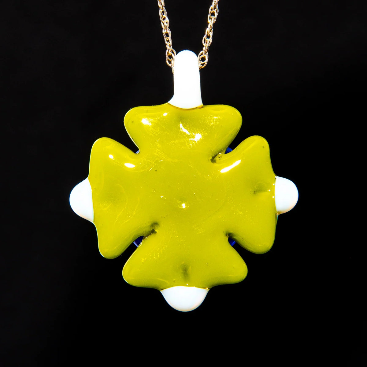 Handmade green and white glass pendant on gold chain with black background