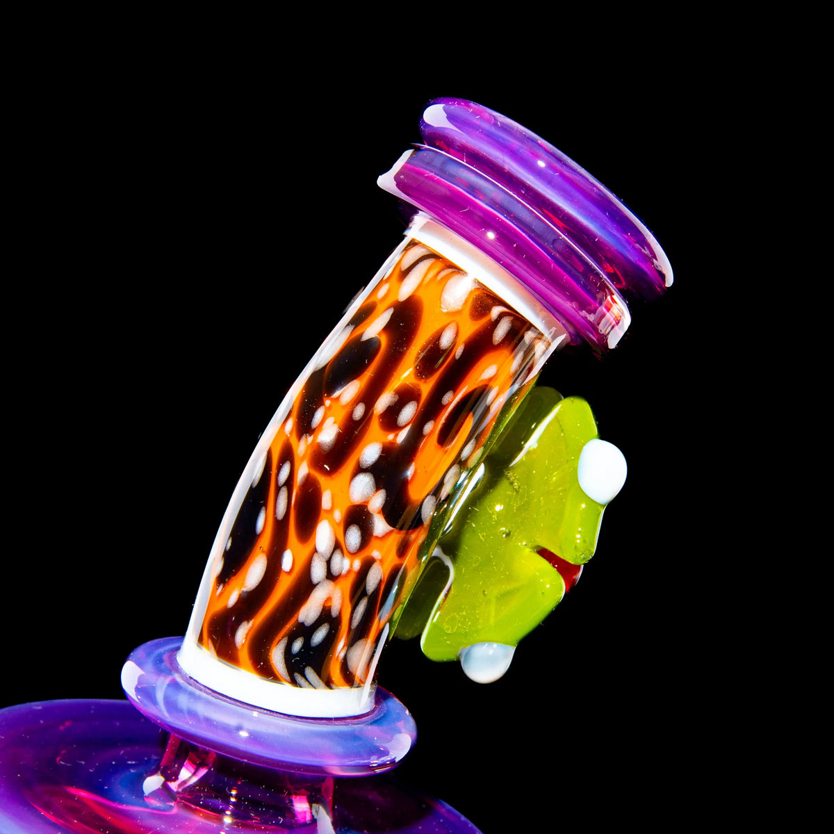 Colorful mini glass smoking pipe with orange, black, and purple patterns on black background