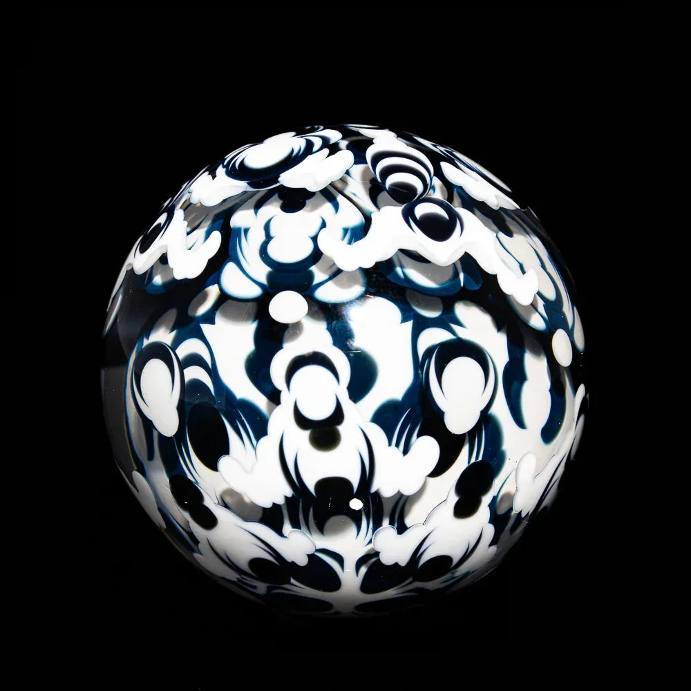 Heady glass marble with intricate black and white patterns on a black background