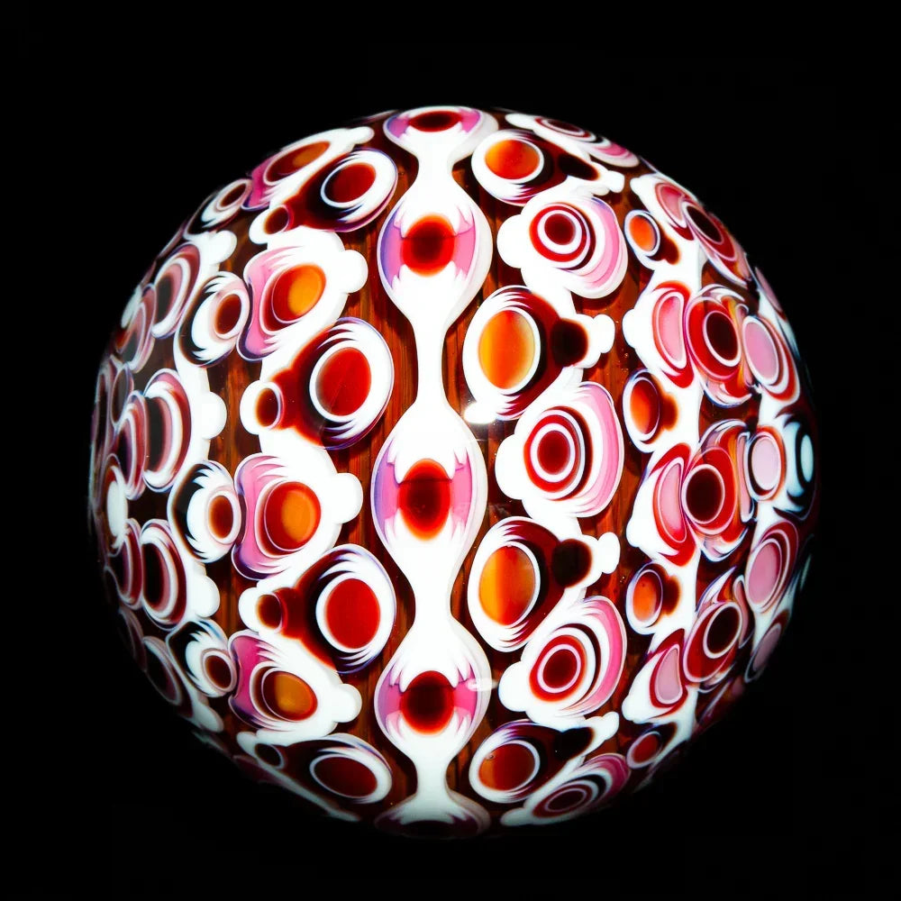 Heady glass art orb with vibrant red, orange, and white patterns on a black background
