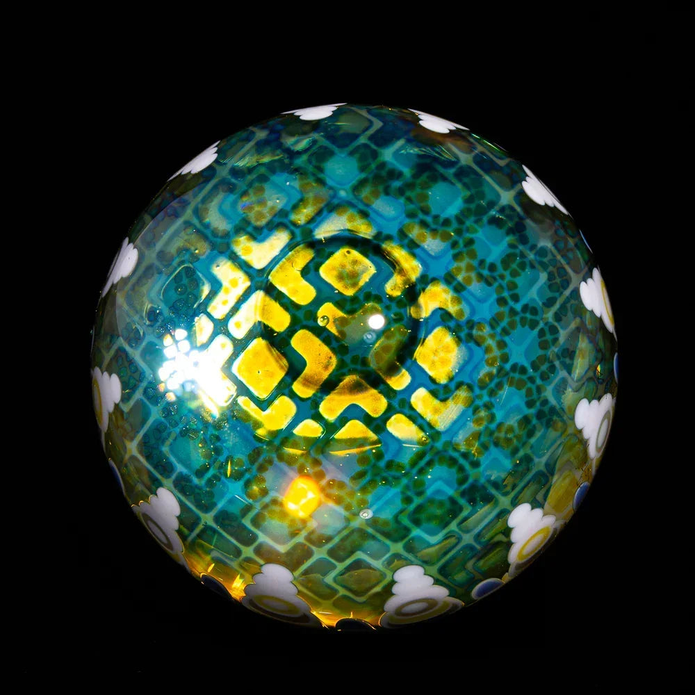 Colorful glass art sphere with intricate yellow, green, and blue patterns and white cloud details