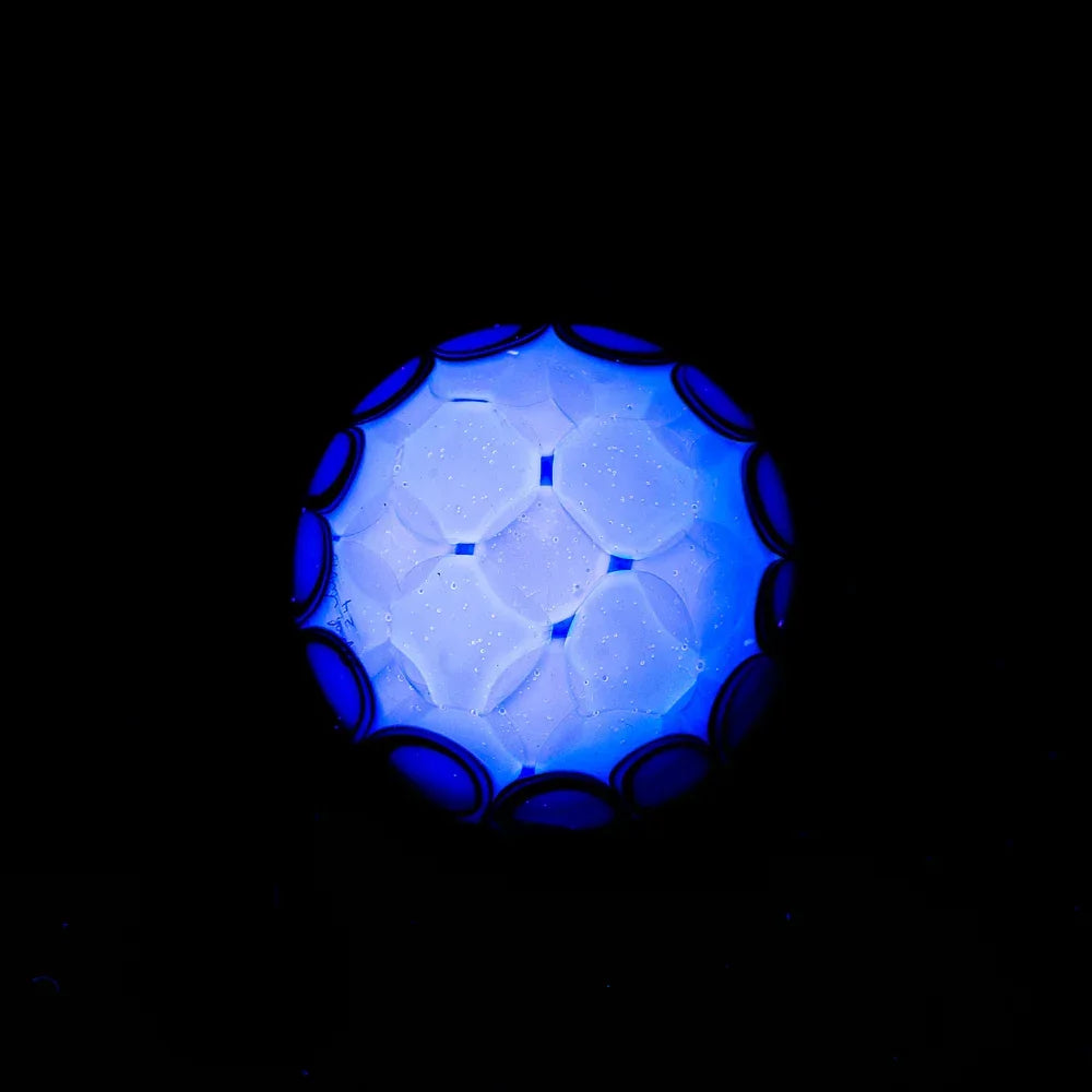 Blue stardust glass marble with geometric patterns and silver fume accents on black background