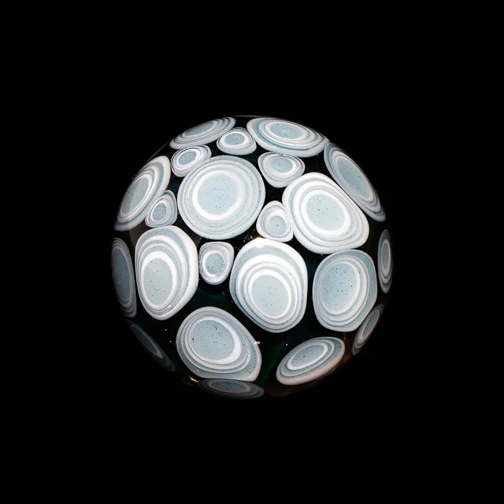 Silver fume glass marble with white spiral vortex pattern on black background
