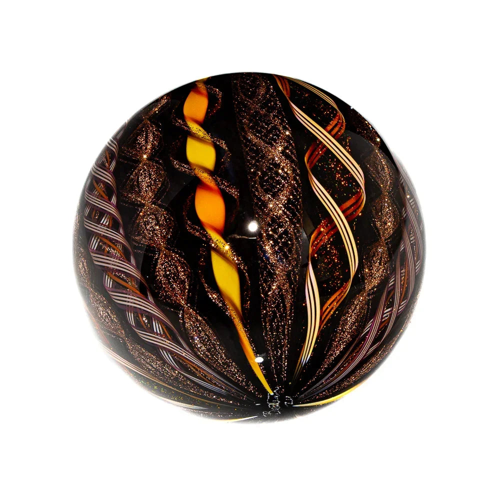 Handcrafted glass marble with glittery swirls and orange-yellow twisting patterns