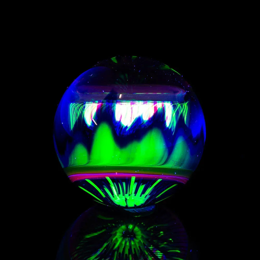 Heady glass orb with vibrant neon green and blue patterns on a black background