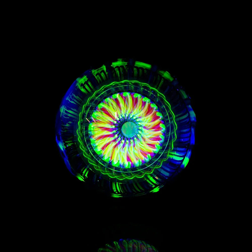 UV-reactive heady glass art orb with vibrant neon colors and intricate patterns on black background