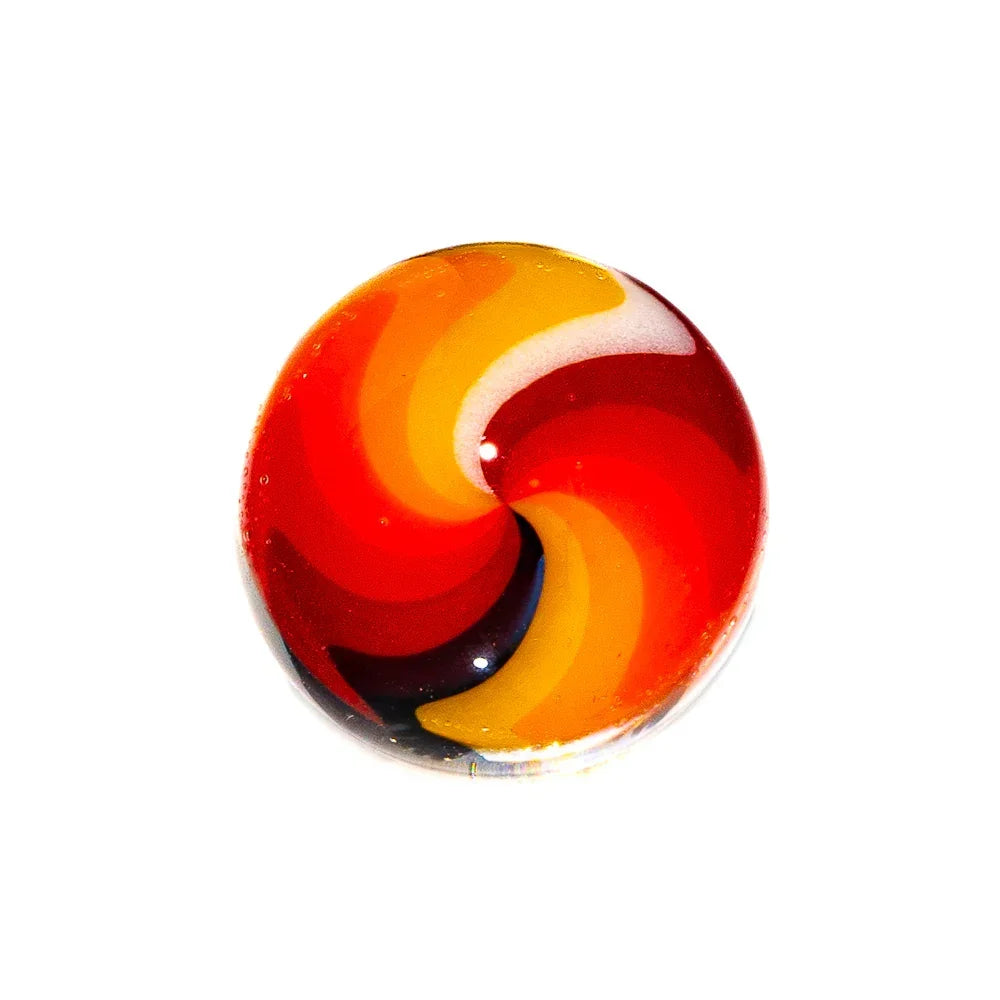 Handblown glass marble with red, orange, and yellow spiral swirl on white background