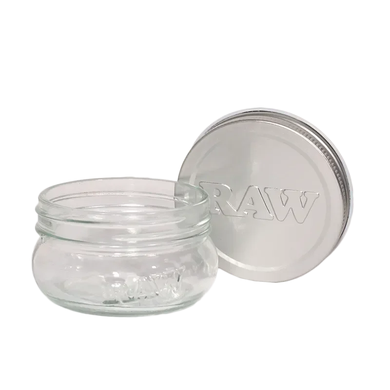 Clear glass storage jar with metal lid labeled RAW, suitable for accessory storage.