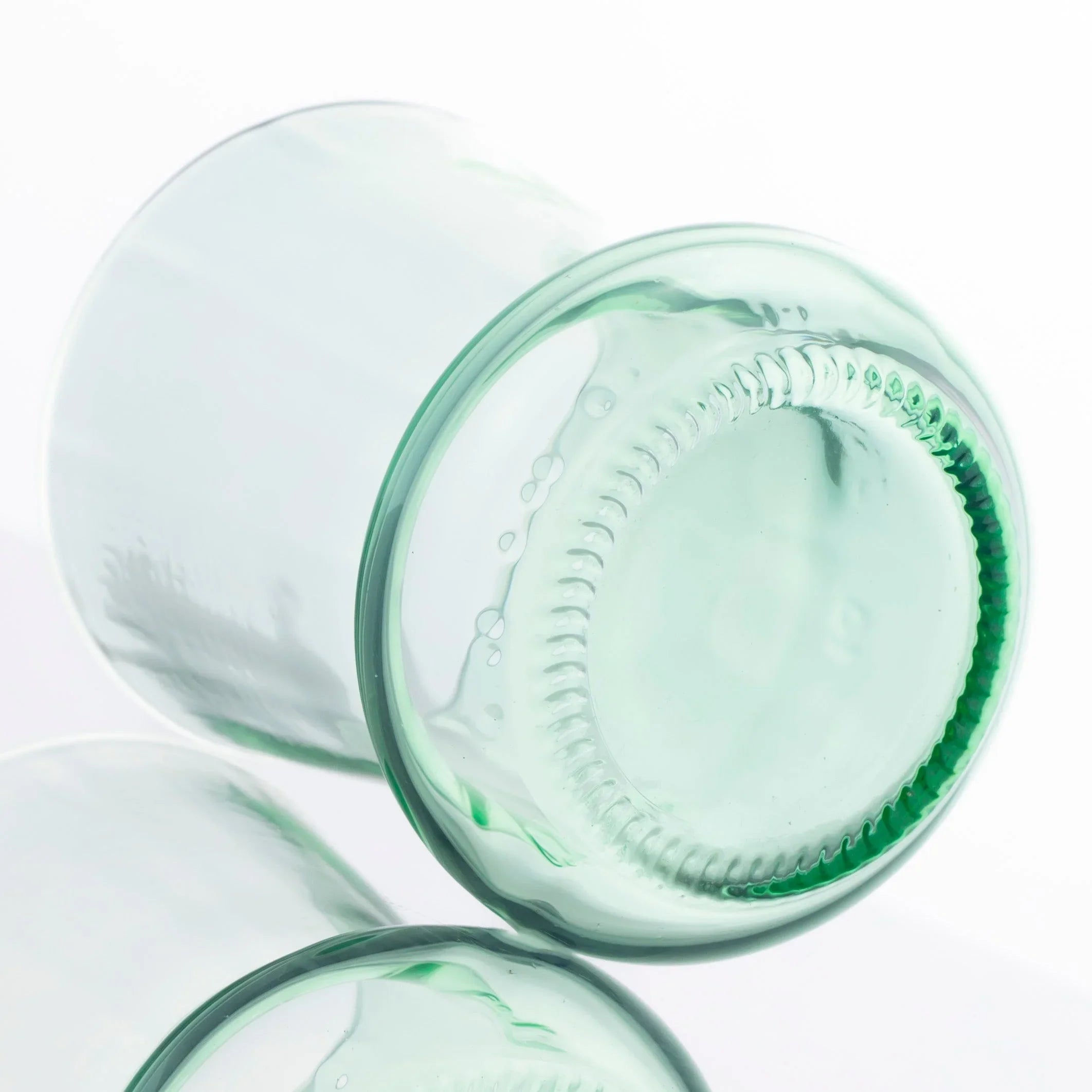 Clear glass cup crafted from upcycled soda bottle with visible bottle base detail