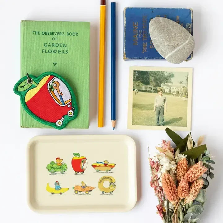 Colorful apple car patch keychain with vintage-style books, pencils, photo, and floral decor.