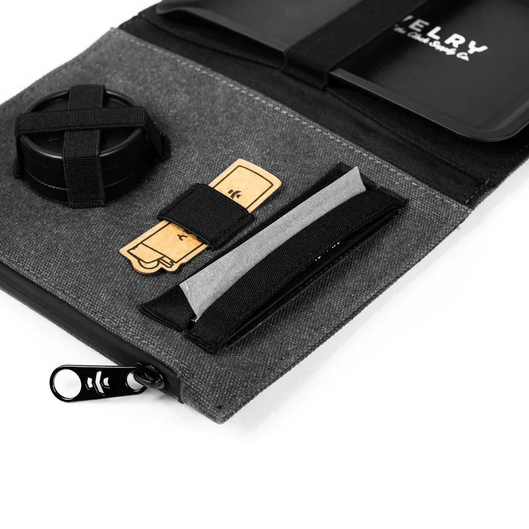 Gray rolling kit with grinder, rolling papers, and tray in organized travel pouch.
