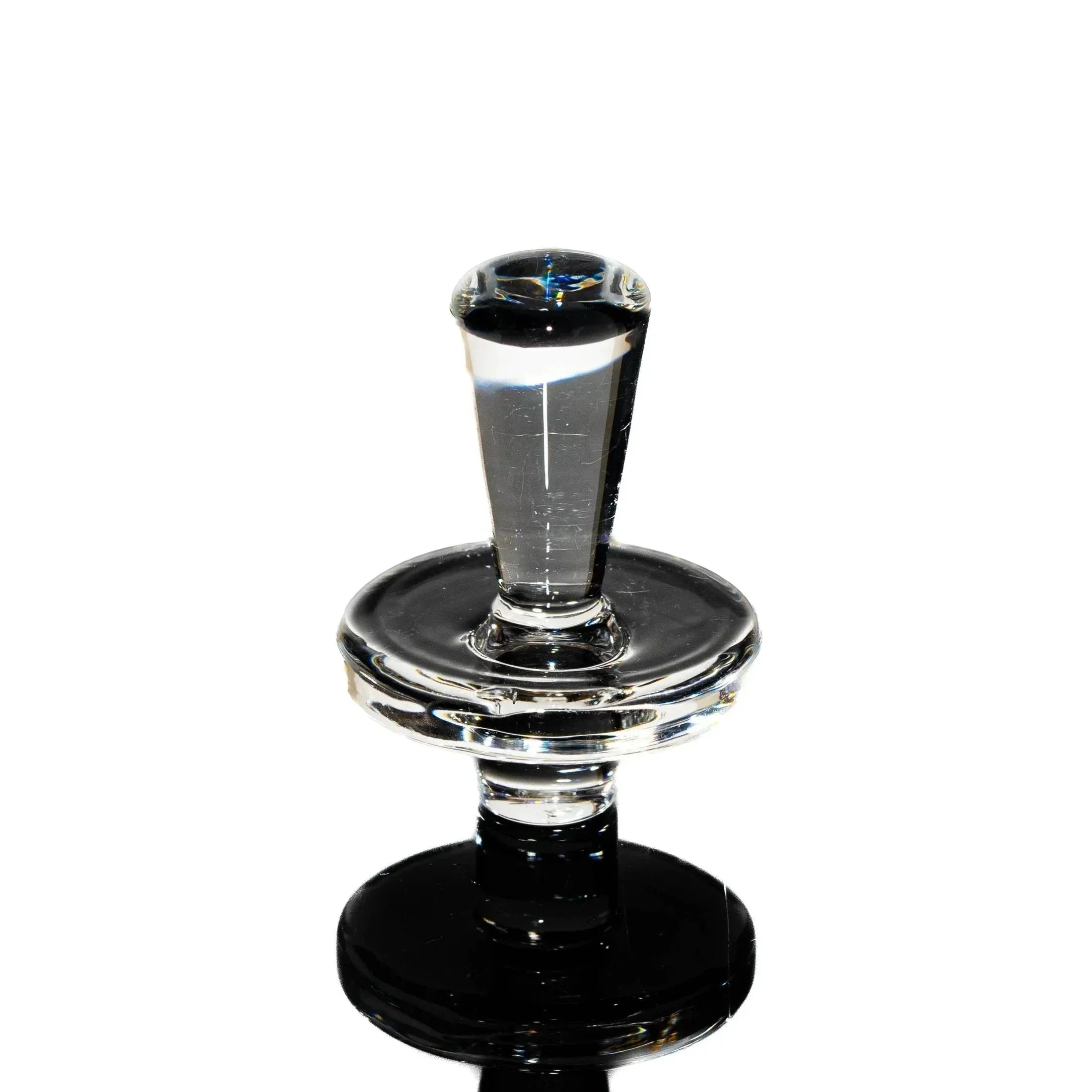 Clear glass carb cap for vaporizer with reflective base on white background