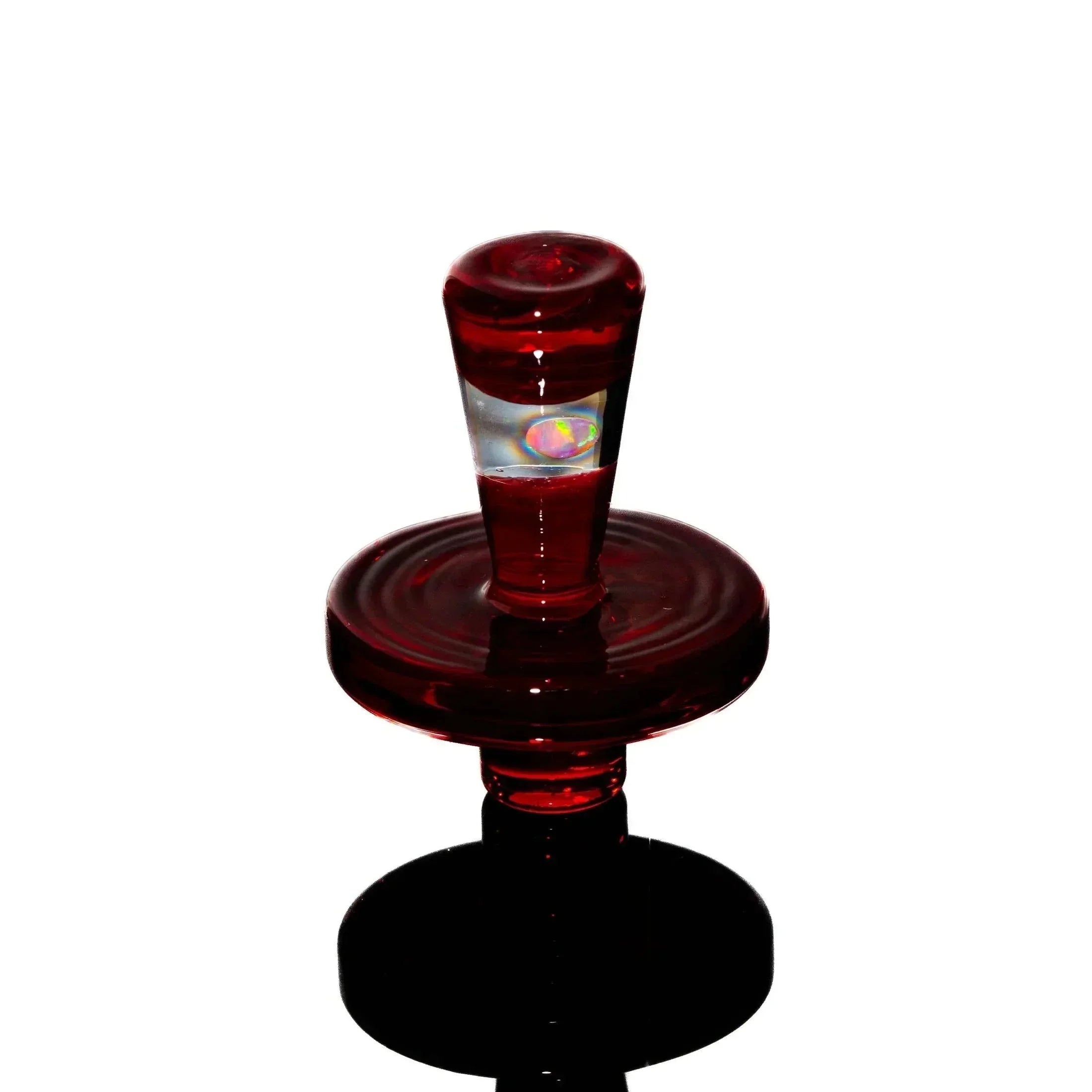 Ruby red glass carb cap with opal accent on white background