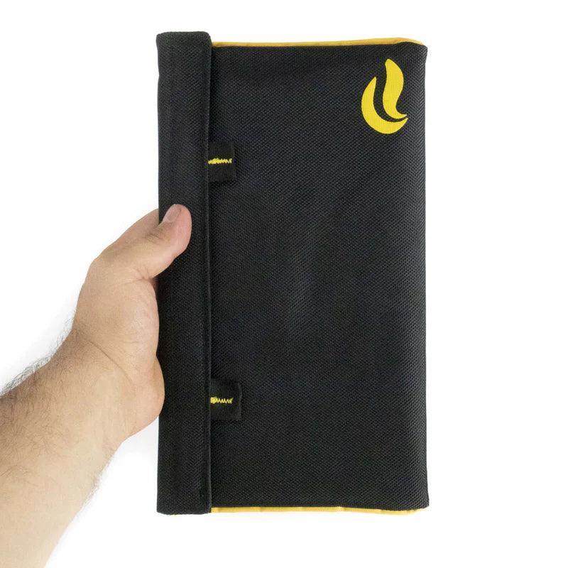 Hand holding a black smell-proof pouch with yellow trim and logo, odor-proof storage bag