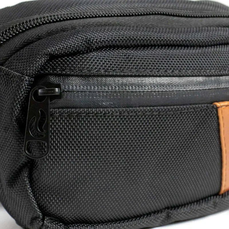Close-up of a black textured hip bag with orange accent and zippered pocket