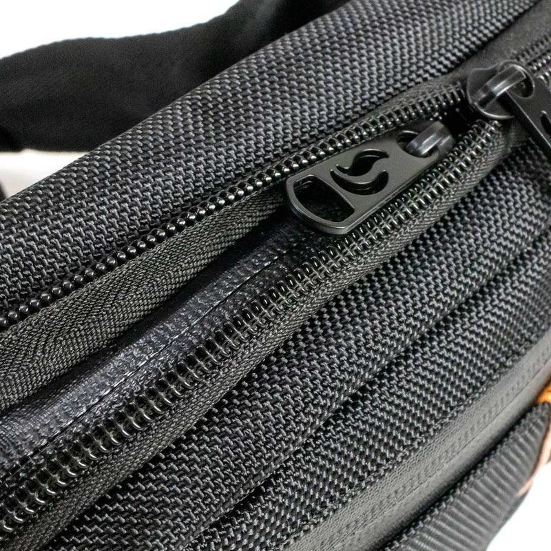 Close-up of black hip bag with durable zippers and textured fabric