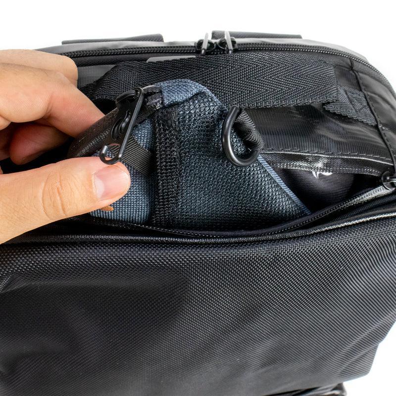 Hand opening black smell-proof bag with inner compartments and secure zippers